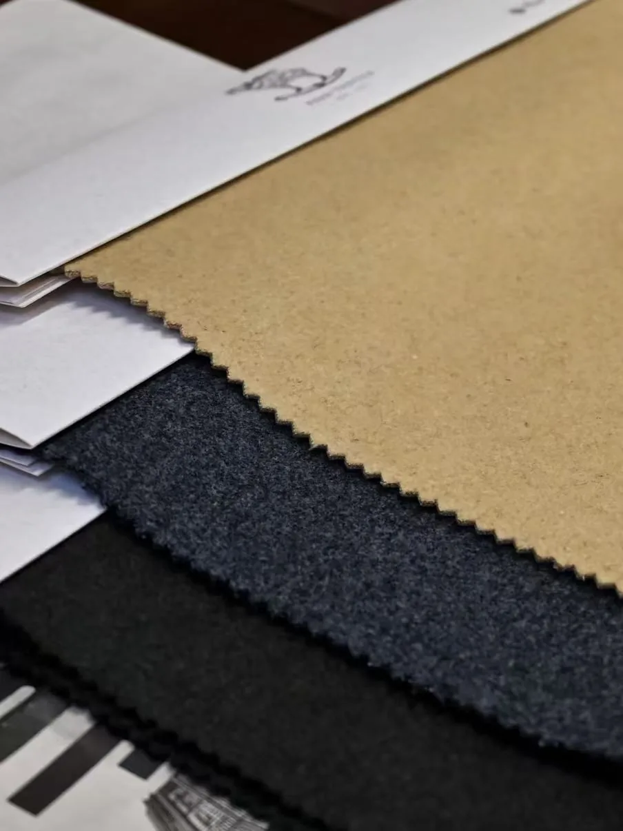 Cut fabric swatches in tan, navy and black laid out with a printed brief